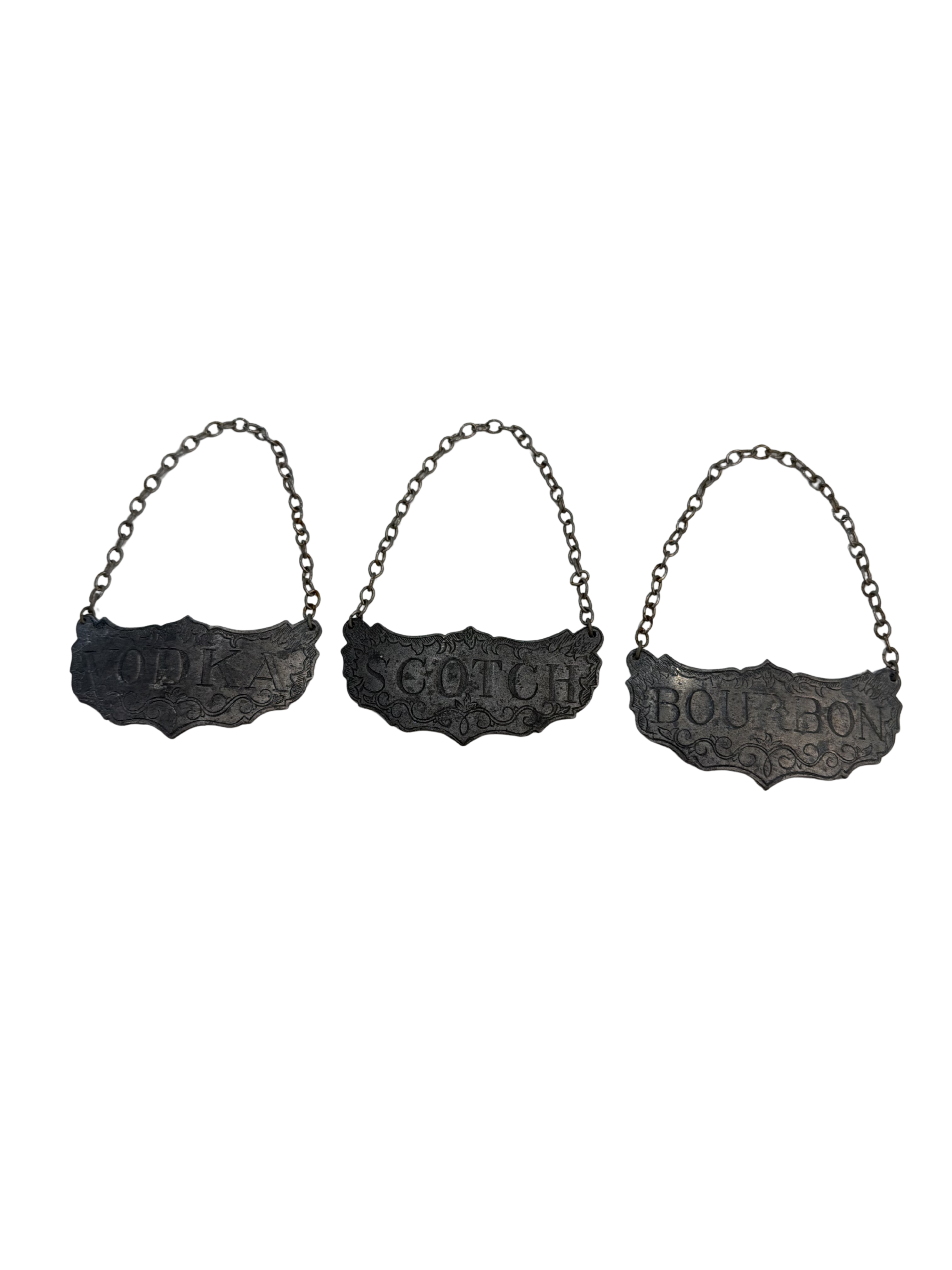 A set of three vintage metal decanter tags for Bourbon, Vodka, and Scotch